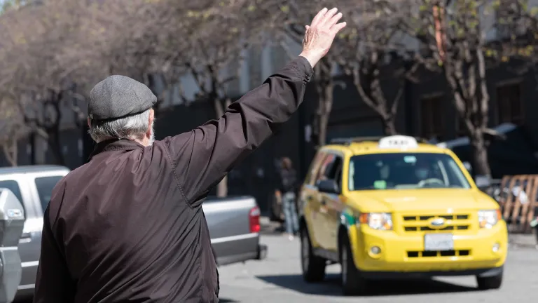 A person hailing a yellow cab.