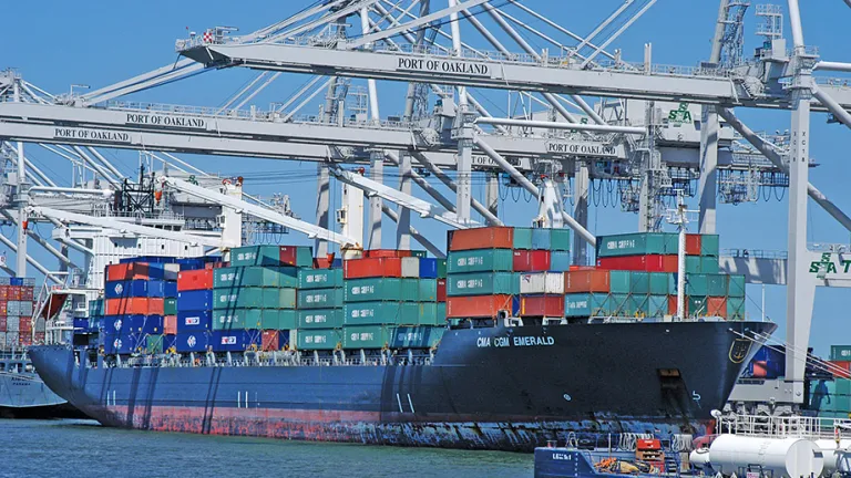 A cargo ship loaded with colorful containers docks at the Port of Oakland.