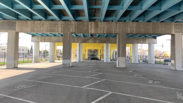 A view across the empty parking lot beneath I-880 at Fruitvale Avenue in Oakland