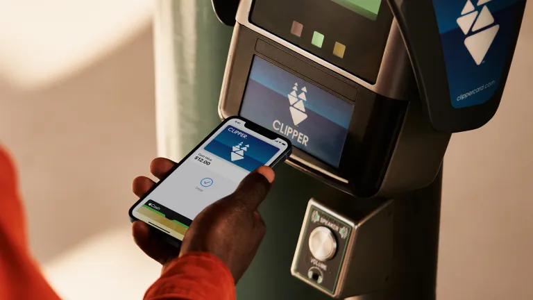 A person paying a transit fare with the Clipper app on their cell phone.