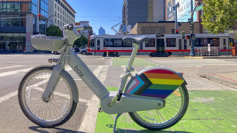 A Bay Wheels bikeshare bike and Muni light rail train in San Francisco.