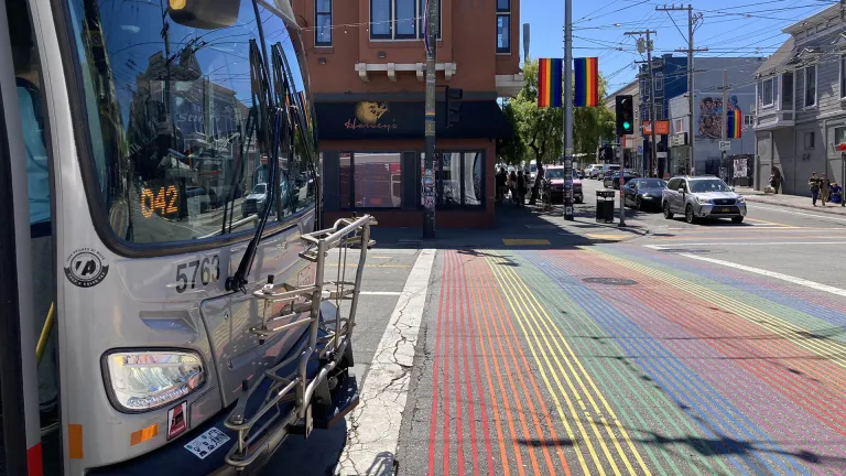 A Muni bus at a rainbow-colored crosswalk in the Castro in San Francisco.
