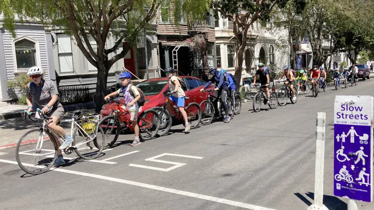 Adults and children riding their bikes home from school as part of a Bike Bus in San Francisco.