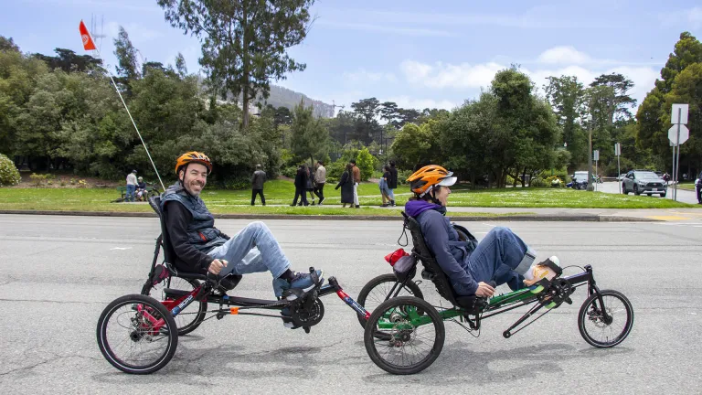 Two cyclists on a tethered pair of recumbent cycles in Golden Gate Park.