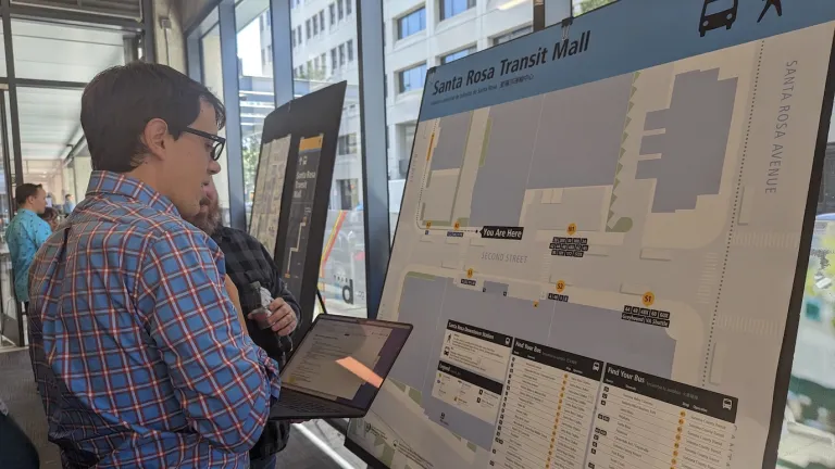 A man looks at a map of the Santa Rosa Transit Mall on a display board.