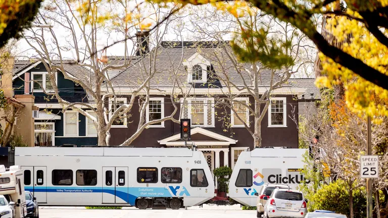 VTA light rail train near a large home on a residential street.