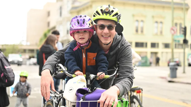 An adult and child celebrating biking together.