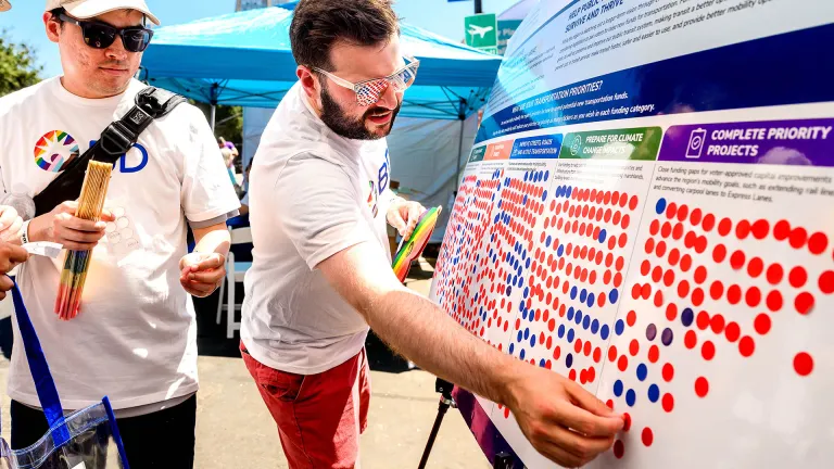 Man places sticker onto foam board to indicate preference for public engagement activity.