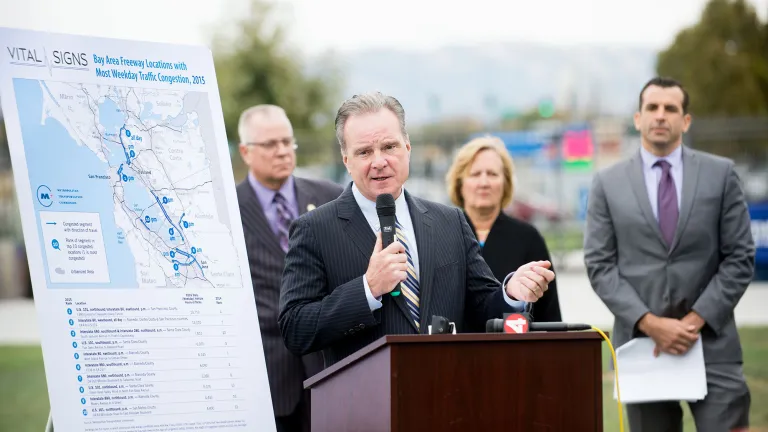 MTC Chair Dave Cortese speaks, while MTC Commissioners Scott Haggerty, Amy Worth and Sam Liccardo look on. 