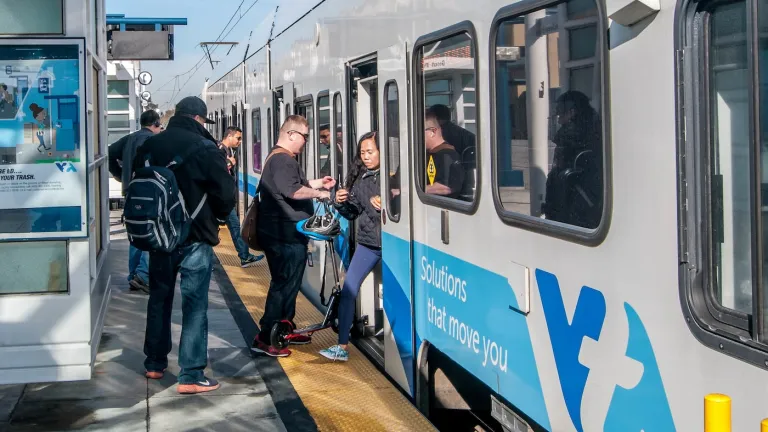 People enter and exit a VTA light rail train.
