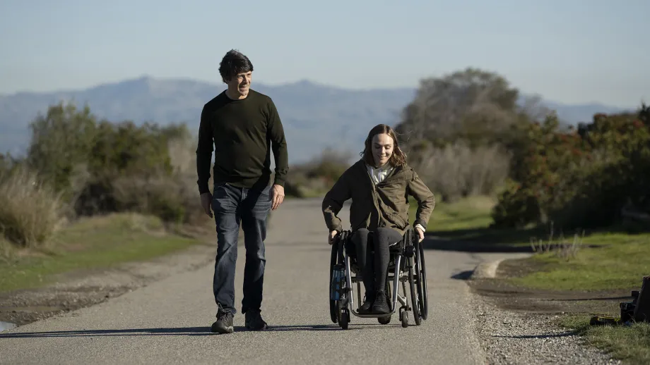 A person walking next to a person in a wheelchair on the Bay Trail.