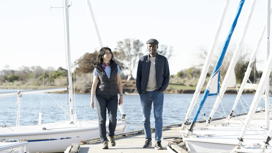 Two people walking on a pier.