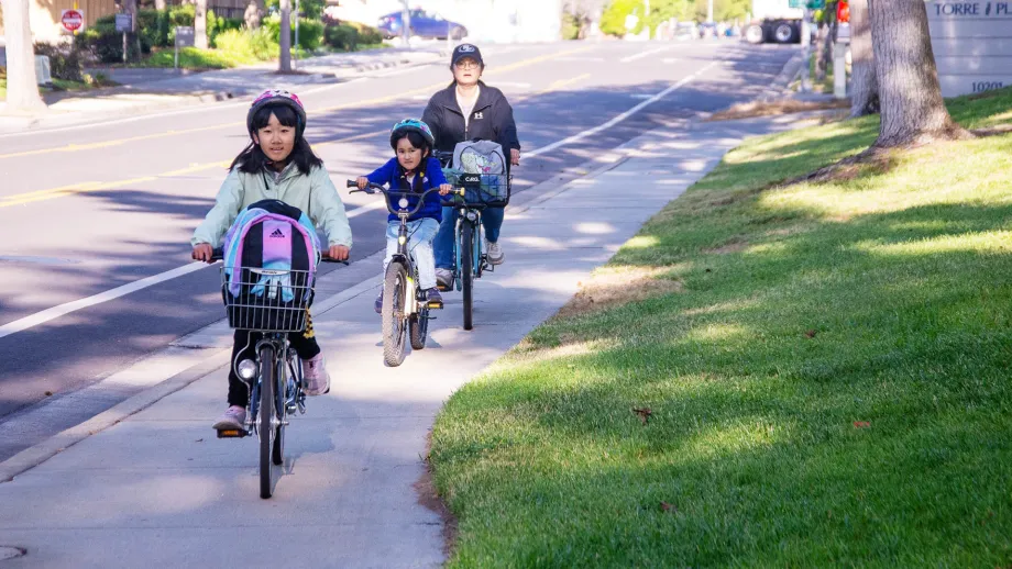 A family biking to school on Bike to Wherever Days 2025.