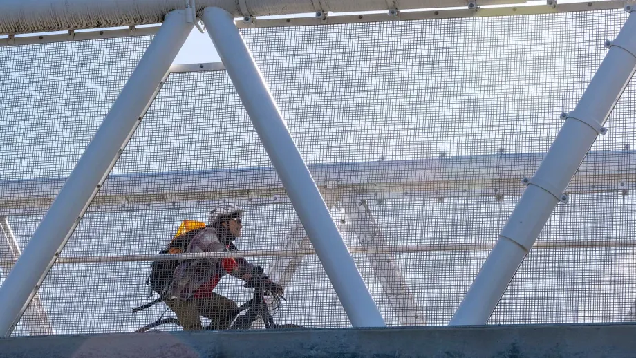 A cyclist rides on a bridge on Bike to Work Day.
