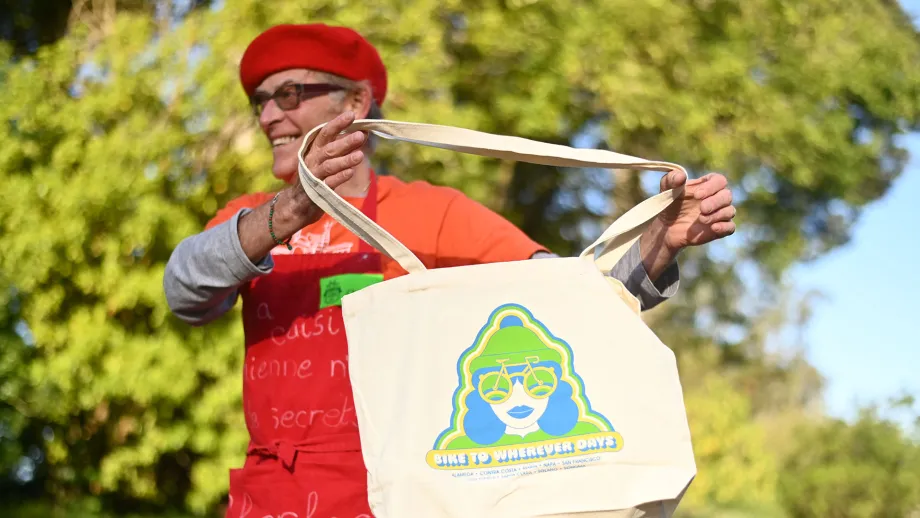 A Bike to Work Day volunteer holds out a totebag.