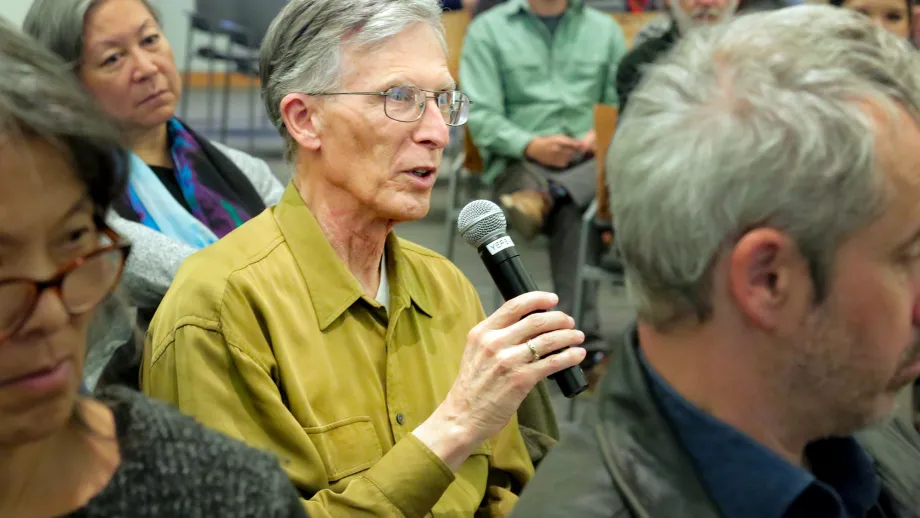 man sitting in a chair with a microphone 