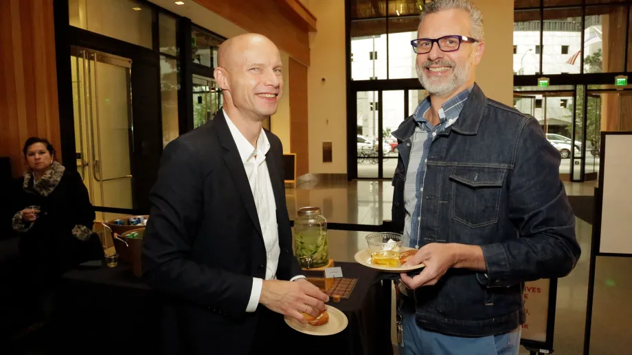 two men smiling while having a conversation