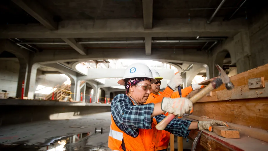 Lily Moses hammers while working in the Milpitas BART Station.