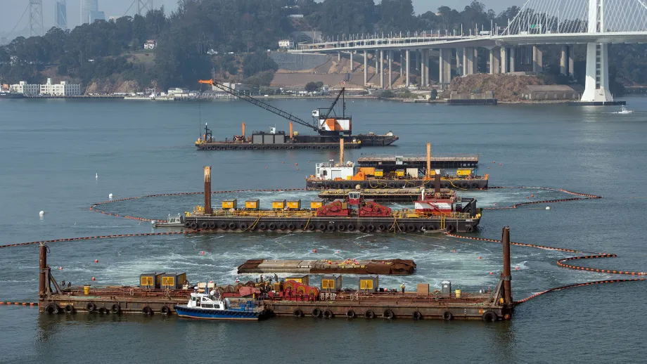 4 large container ships in front of the bay bridge