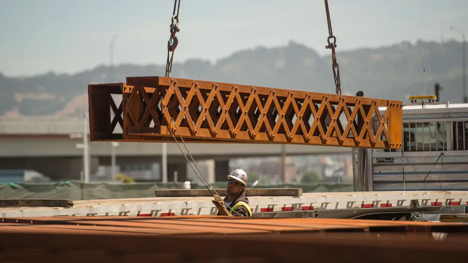 construction worker guiding a steel beam