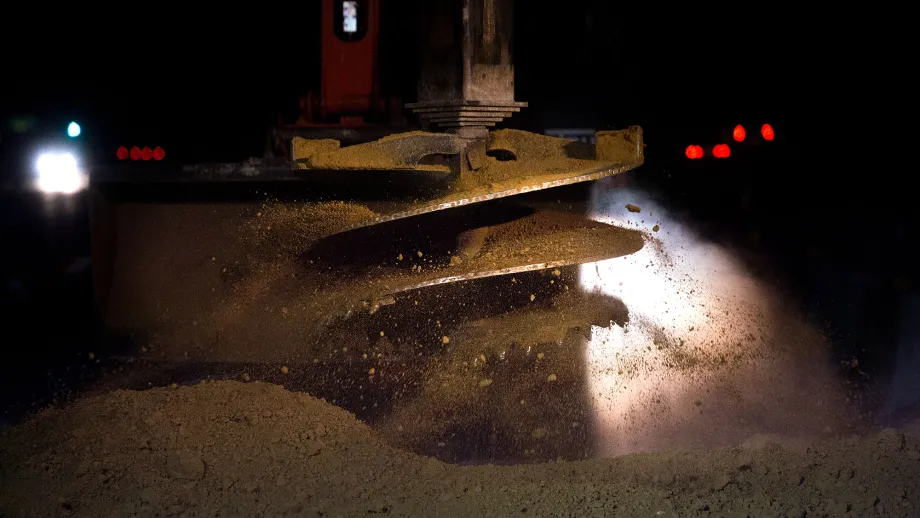 Drill attachment pushes through the earth to pre-drill shafts for the express lane sign foundations.