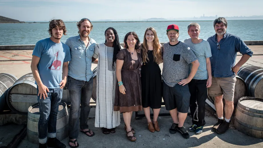 group of people posing for picture in front of water