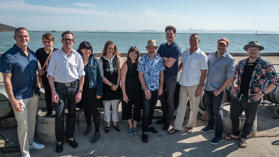 group of people posing for picture in front of water