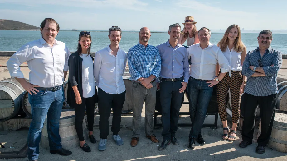 group of people posing for picture in front of water