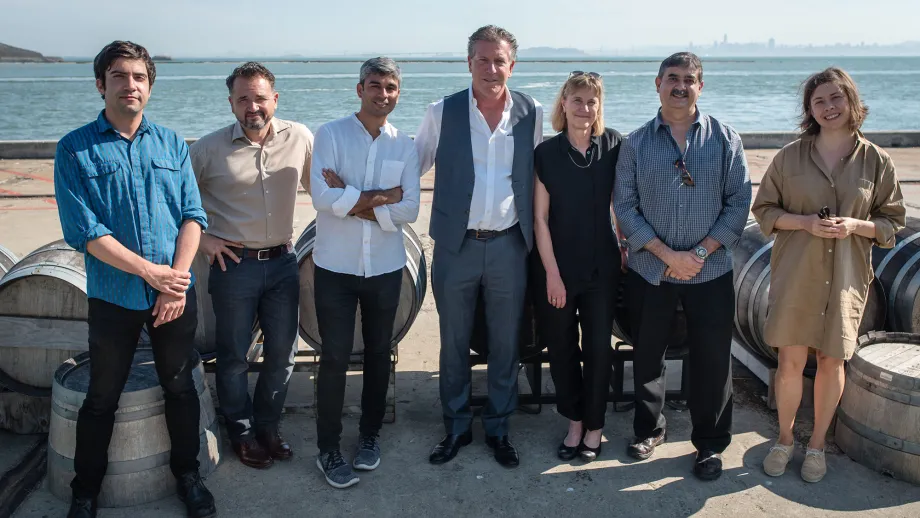 group of people posing for picture in front of water