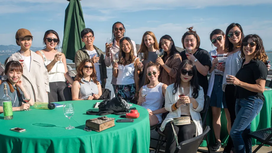 group of people posing for picture in front of water