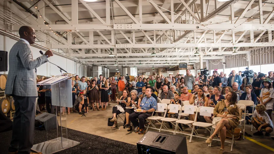 crowd of people listening to a speaker on stage