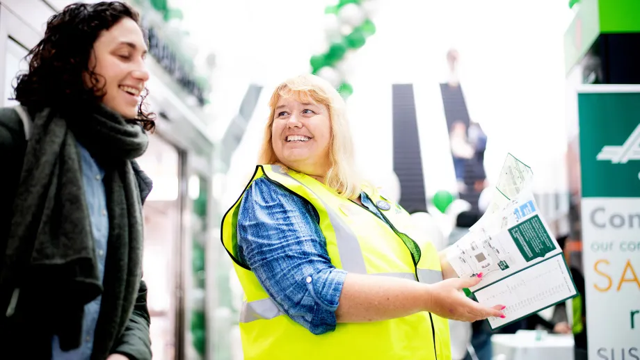 AC Transit ambassador Tammy Kyllo helps a commuter navigate the Salesforce Transit Center during the first day of AC Transit Service