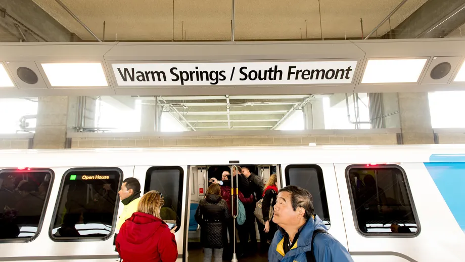 people getting on train at warm spring station