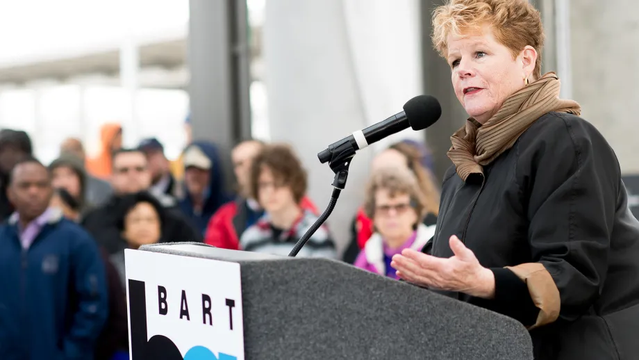Woman at podium talking to a crowd