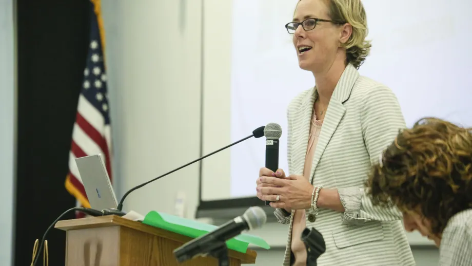 woman holding microphone next to a podium