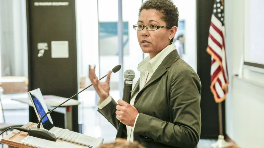 young adult holding microphone next to a podium