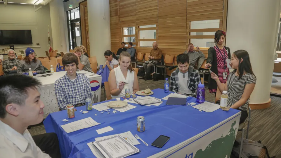 group of people sitting around a table talking