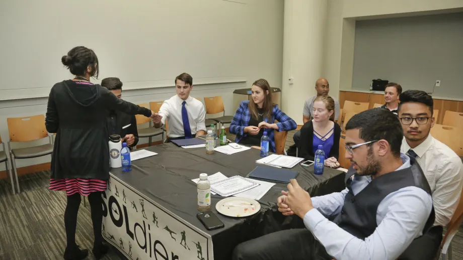 group of people sitting around a table talking