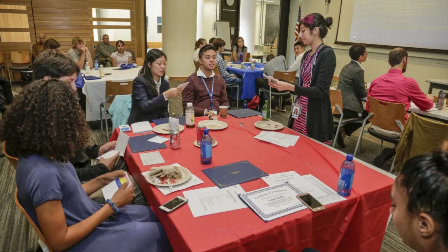 group of people sitting around a table talking