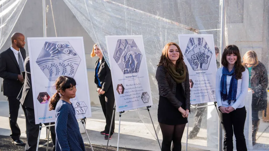 The medallion artists pose with their designs.