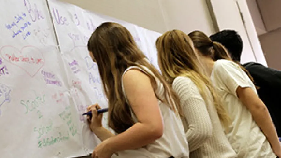 Students write their ideas for transportation alternatives on poster paper.