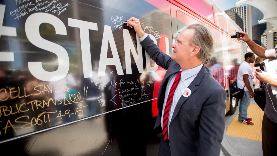 MTC Chair Dave Cortese signing the wrapped VTA bus