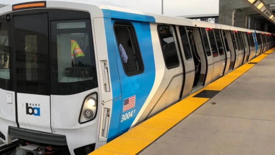 A new BART train at a BART station platform.