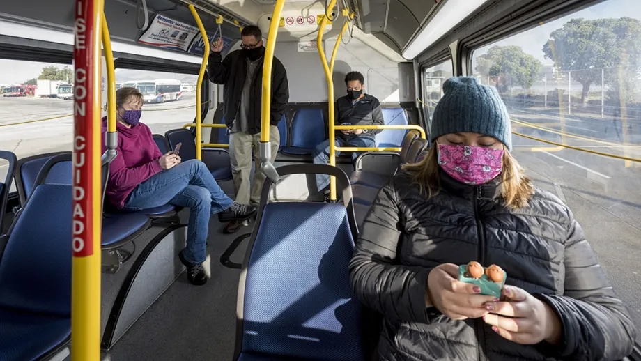 Bus riders using cellphones.