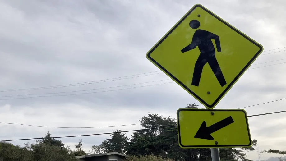 Yellow sign indicating a pedestrian crossing.