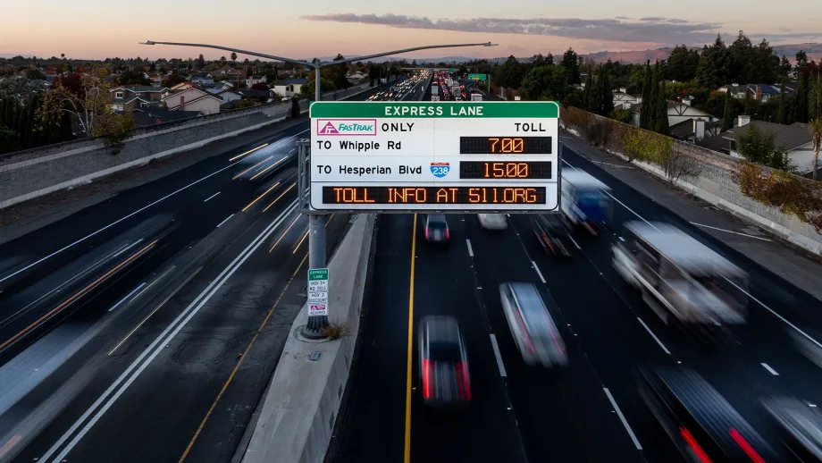 High angle view of a highway and Express Lanes sign at night.