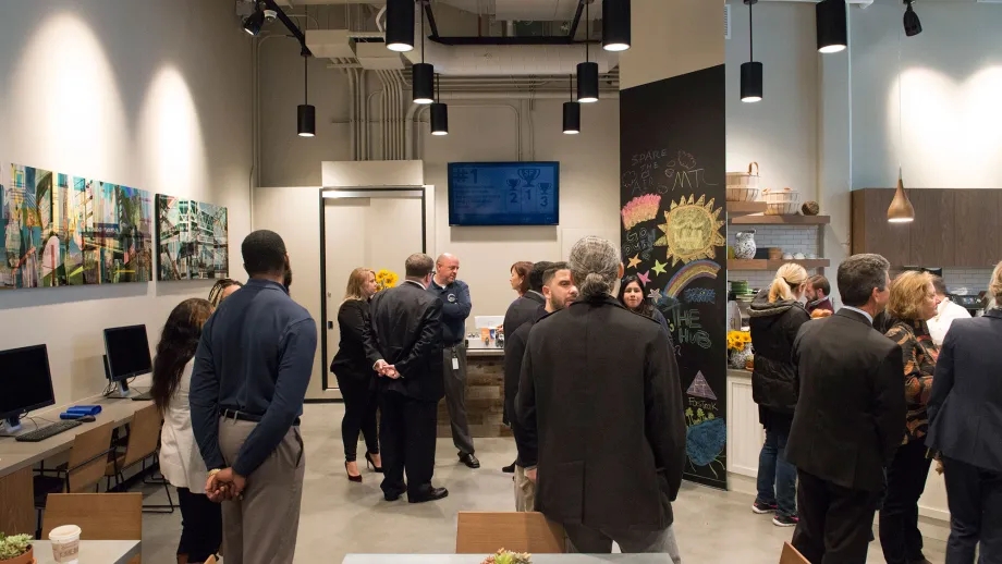 The Hub staff speak with visitors during the center's soft opening event. 