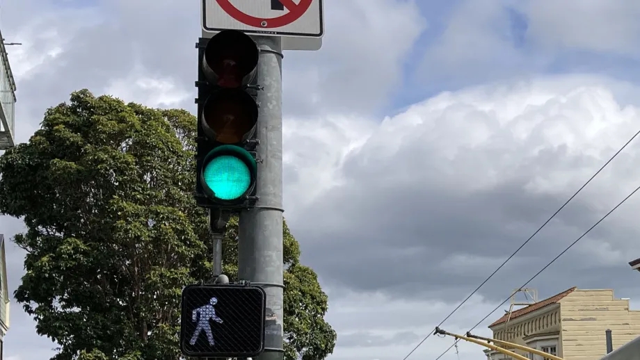 A bus traveling through an intersection with a green traffic light.