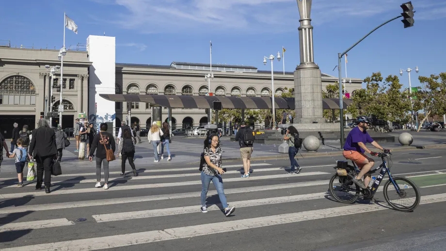 Pedestrians and cyclists in the crosswalk at the Ferry Building in San Francisco.