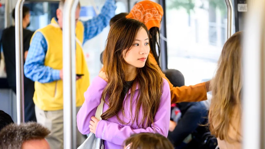 A woman riding transit on a crowded Muni train.